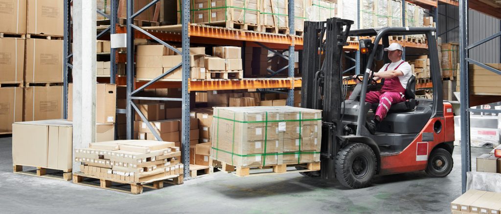 man driving forklife carrying a pallet