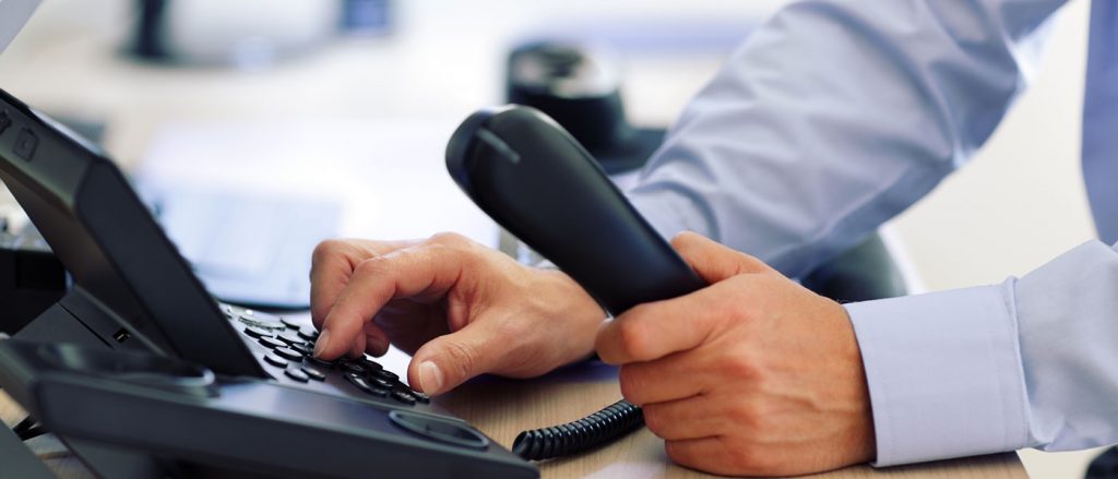 man making a phone call on office phone