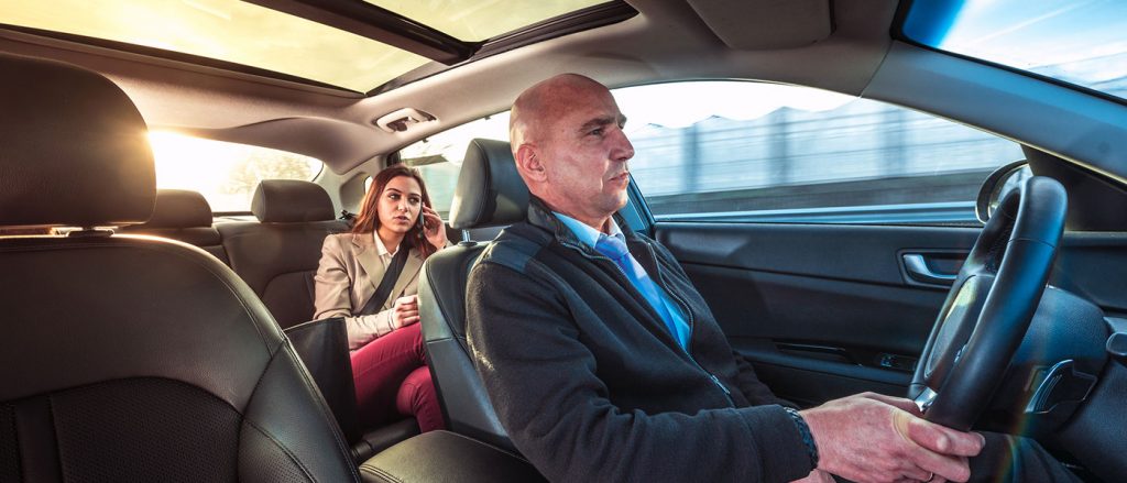 woman being driven in a car while on a phone call