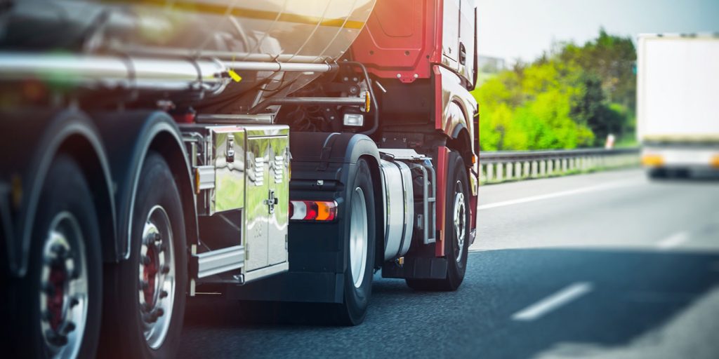 red semi truck pulling a tanker trailer