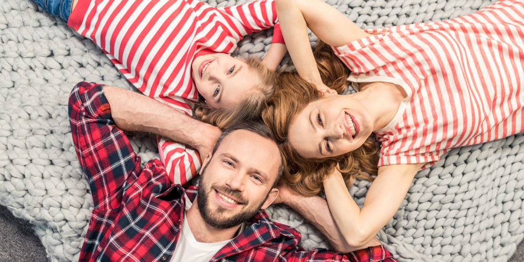 family laying on a rug on their backs